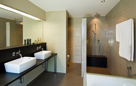 Badezimmer mit bodenebener Dusche und zwei Lavabos