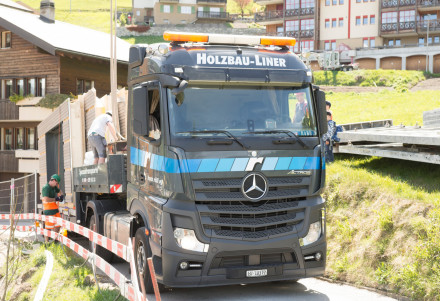 Un camion transporte des éléments sur une route étroite.