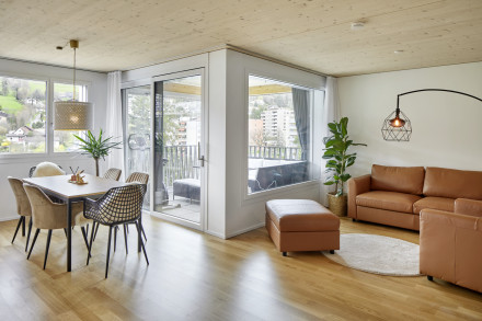 Appartement avec parquet et plafond en bois avec vue du salon/salle à manger vers la loggia
